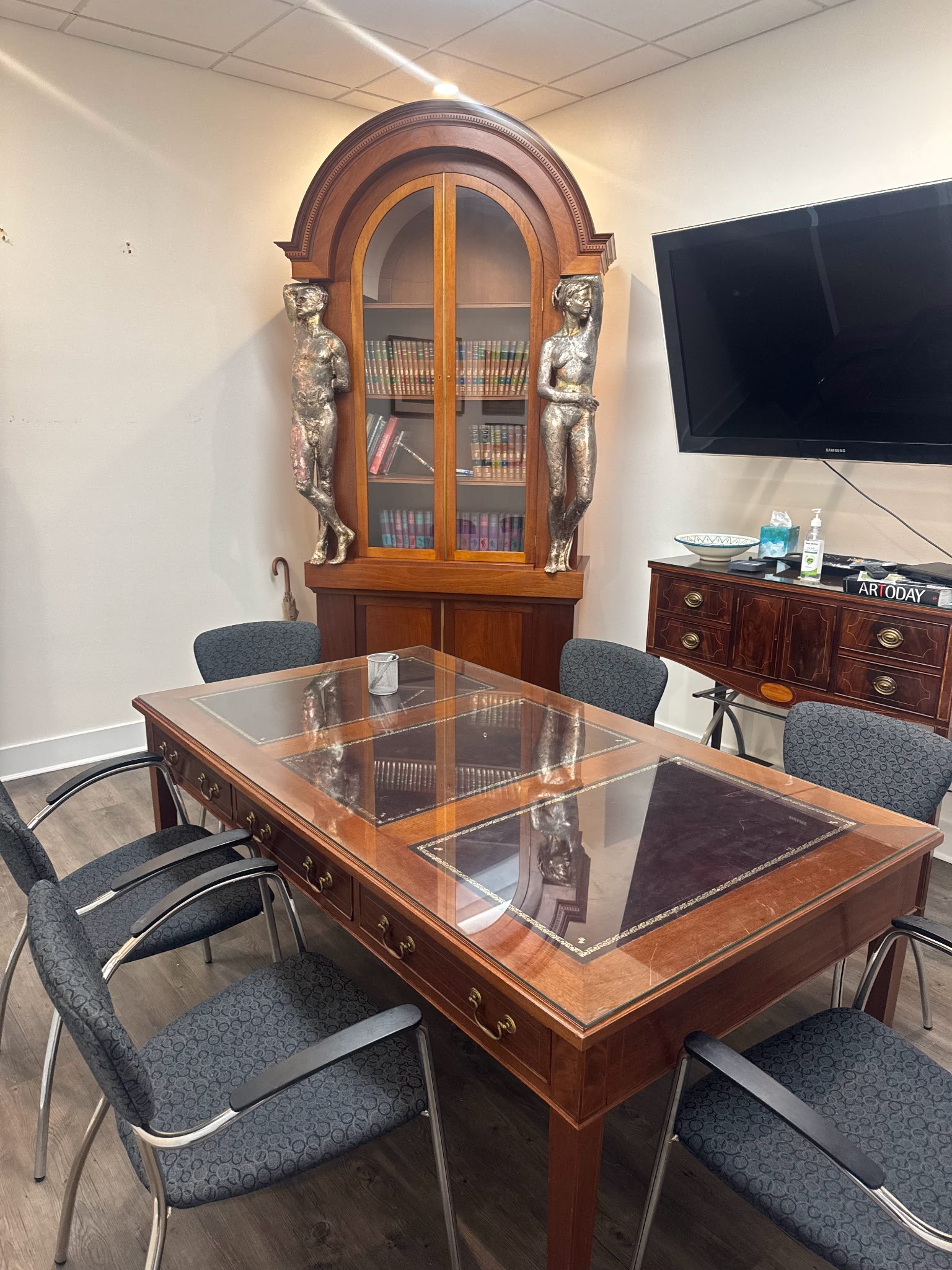 Meeting area with a table, bookshelves, and TV